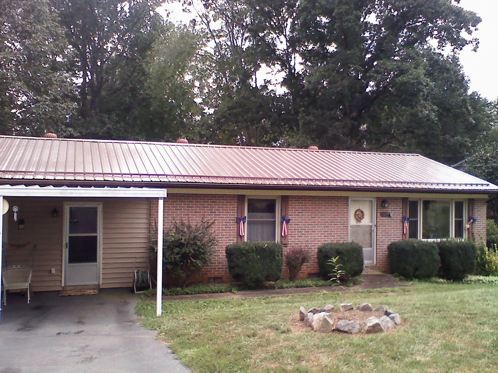 Bronze metal roof and carport on a brick ranch home — Roof Repair work by our crew in North Brookfield